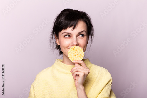 beautiful girl in a yellow sweater holds a sponge in her hands