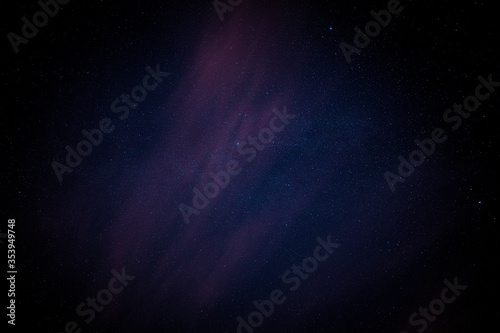 Night sky stars extreme detail background with cloud, a faint outline of the Milky Way and blue, pink and purple colours