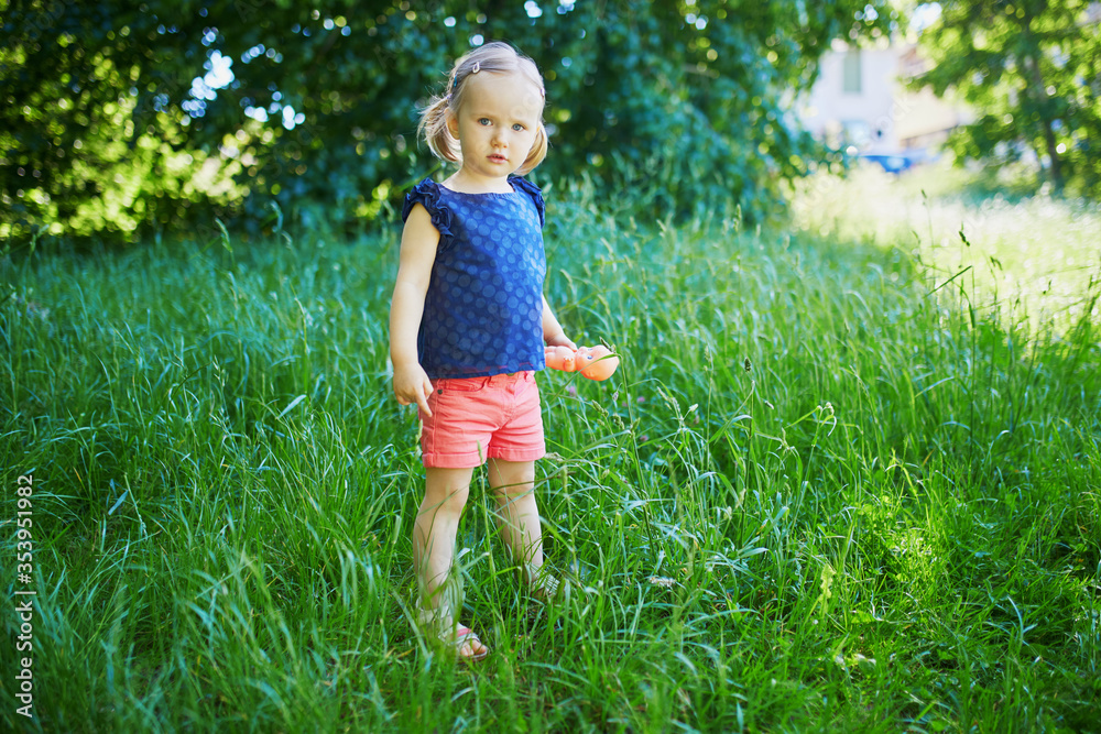 Adorable toddler girl walking in park or forest Adorable toddler girl walking in park or forest