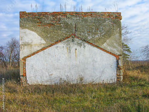 Wall of a house destroyed several years ago by a technogenic cataclysms. The concept of protection against natural cataclysms and technogenic disasters. photo