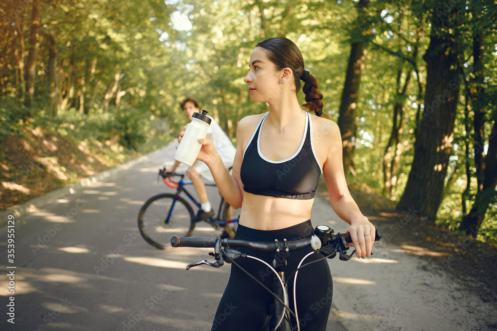 Obraz premium People with a bikes. Couple in a forest. Morning bike ride.
