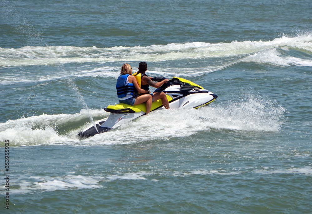 Two men riding tandem on a speeding jet ski.

