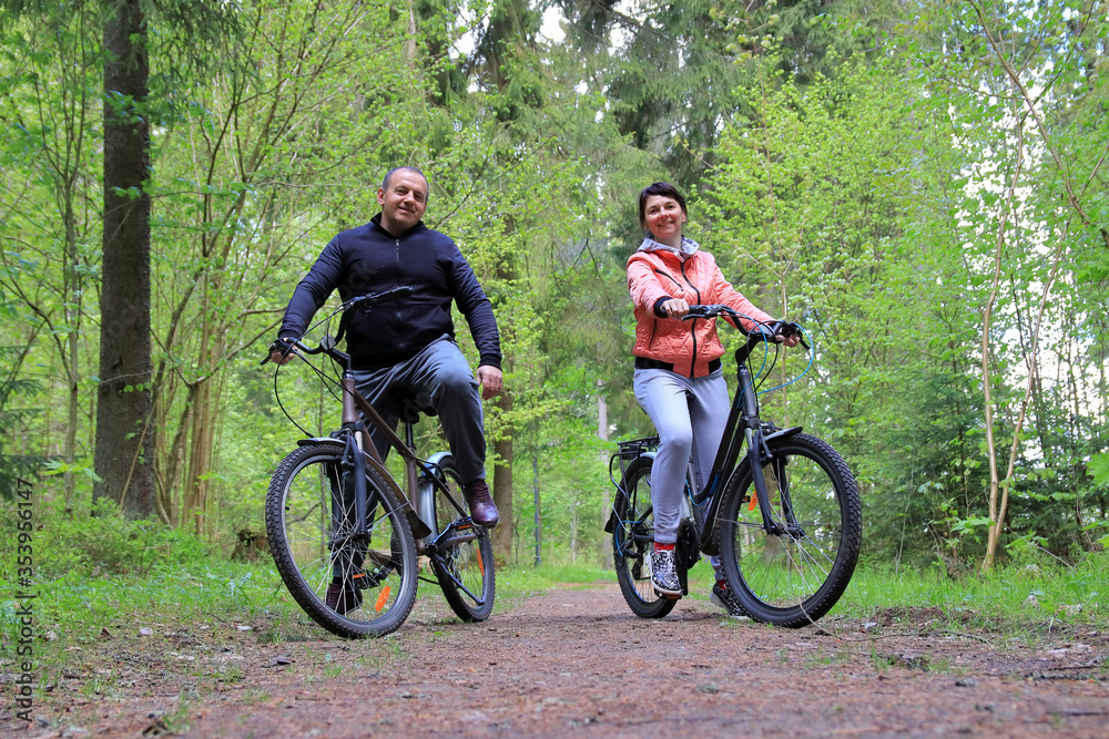 couple on bikes in the forest couple on bikes in the forest