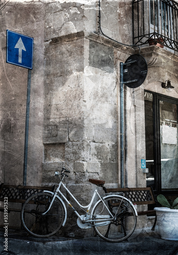 White Bicycle on the Corner Chained to the Bench in Ortygia  Syracuse  Sicily  Italy