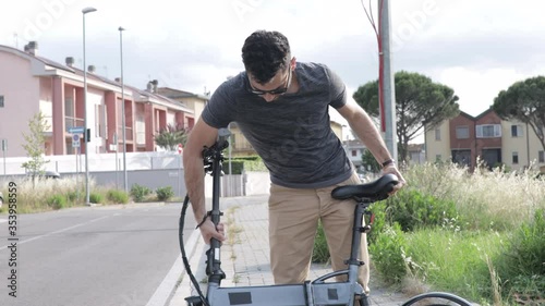 Attractive man unfolds his bicycle and leaves, foldable bike concept