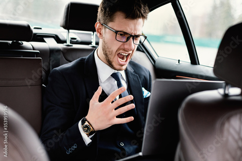Young businessman using laptop sitting in car © Prostock-studio