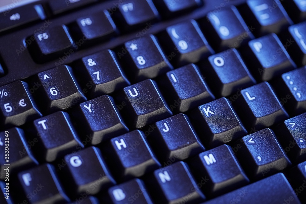 Detail of a black keyboard in blue light Detail of a black keyboard in blue light