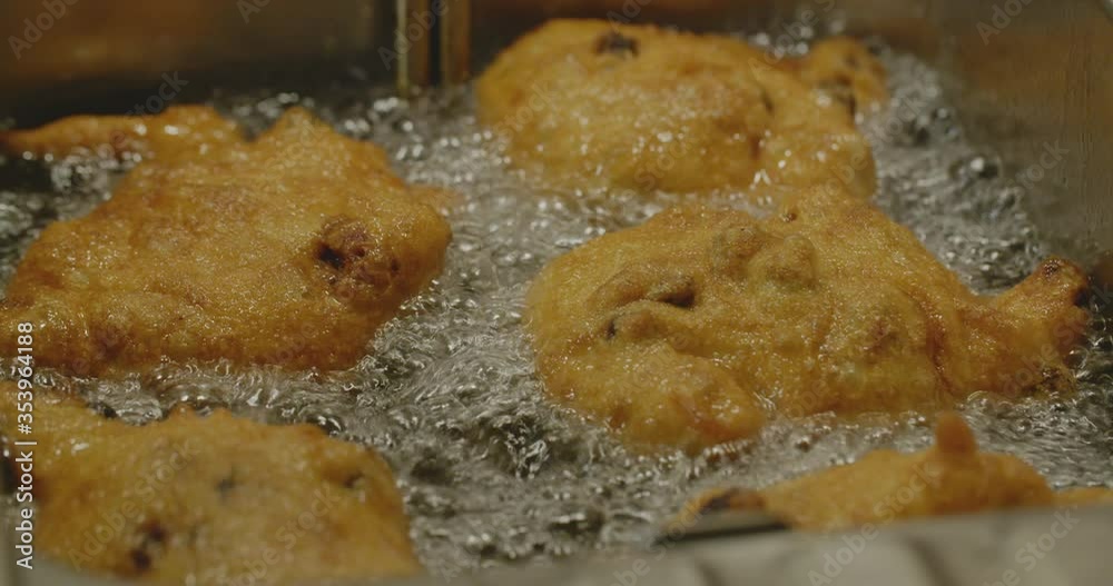 Deep frying oliebollen - a typical Dutch pastry eaten at the end of the calendar year. Deep frying oliebollen - a typical Dutch pastry eaten at the end of the calendar year.