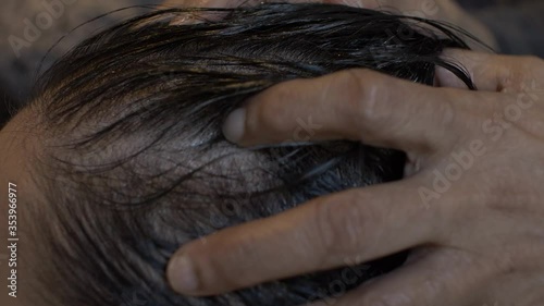 Young Asian Female Getting Oil Massaged Into Her Scalp And Hair. Locked Off, Side View , Close Up photo