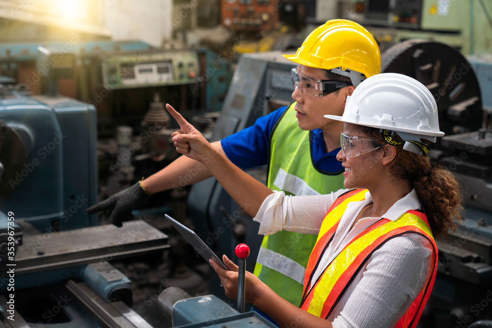 Asian men and African American women are working in industrial plants. Hold the tablet in your hand to see how the machine works. Asian men and African American women are working in industrial plants. Hold the tablet in your hand to see how the machine works.