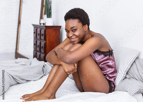 Stay home alone and relax. Girls sitting on bed with crossed legs in bedroom interior