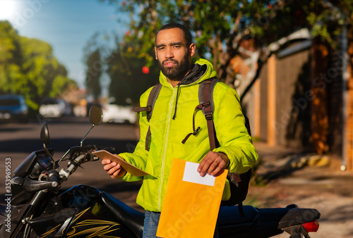 Portrait of delivery man with his motorcycle with delivery. Parcel delivery concept.