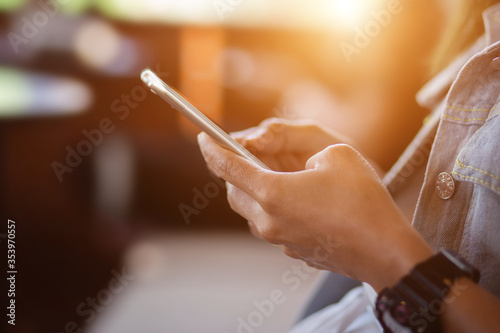 Woman holding mobile phone on blur background
