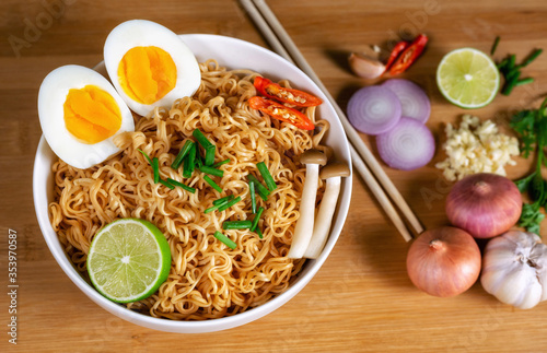 Instant noodles in bowl on wood background top view, Asian meal on a table.