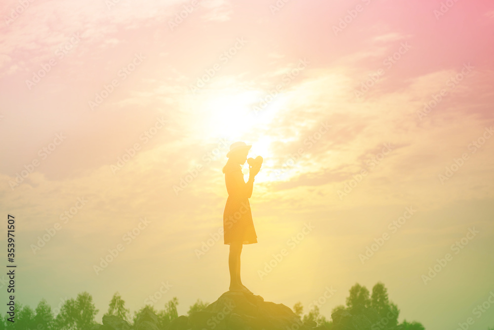 Silhouette of woman praying over beautiful sky background Silhouette of woman praying over beautiful sky background