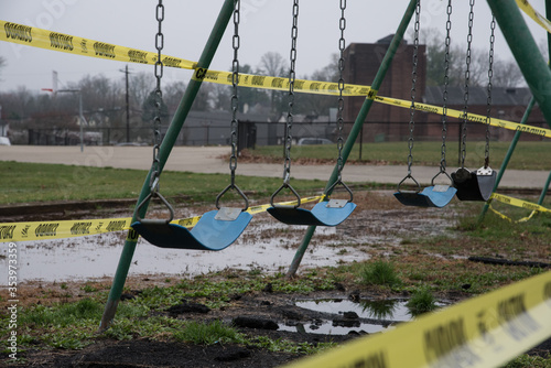 A swingset at a playground, bound in caution tape during the COVID-19 quarantine. 