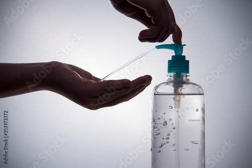 Hand sanitizer or soap being dispensed from a dispenser against a white background. 