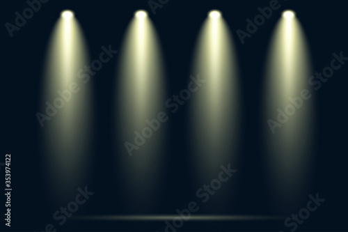 Four spotlights shining down on empty dark stage with dramatic yellow light beams and smoke effect