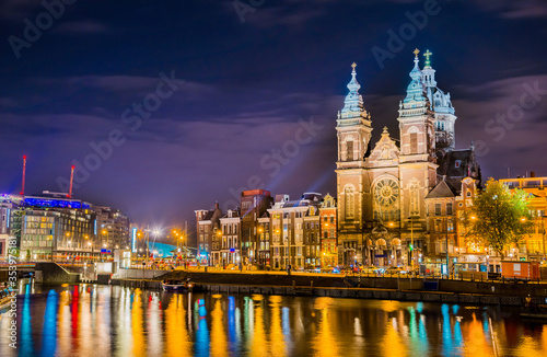 Night city view of Amsterdam canal and Basilica of Saint Nicholas  Holland  Netherlands.