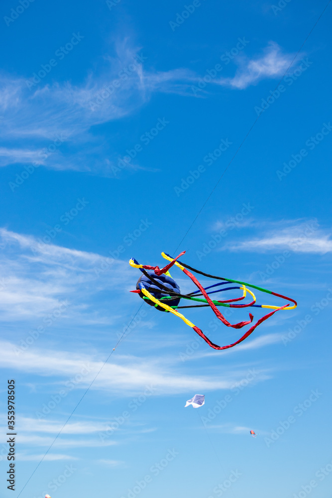Long tailed red, black, blue & yellow kite flying above depok Beach at the Jogja air show in yogyakarta, Indonesia Long tailed red, black, blue & yellow kite flying above depok Beach at the Jogja air show in yogyakarta, Indonesia