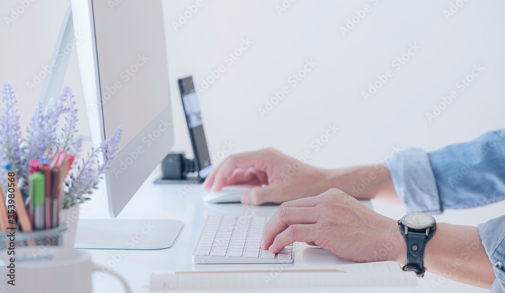 Cropped shot of man hands working with desktop computer while sitting in modern office. Cropped shot of man hands working with desktop computer while sitting in modern office.