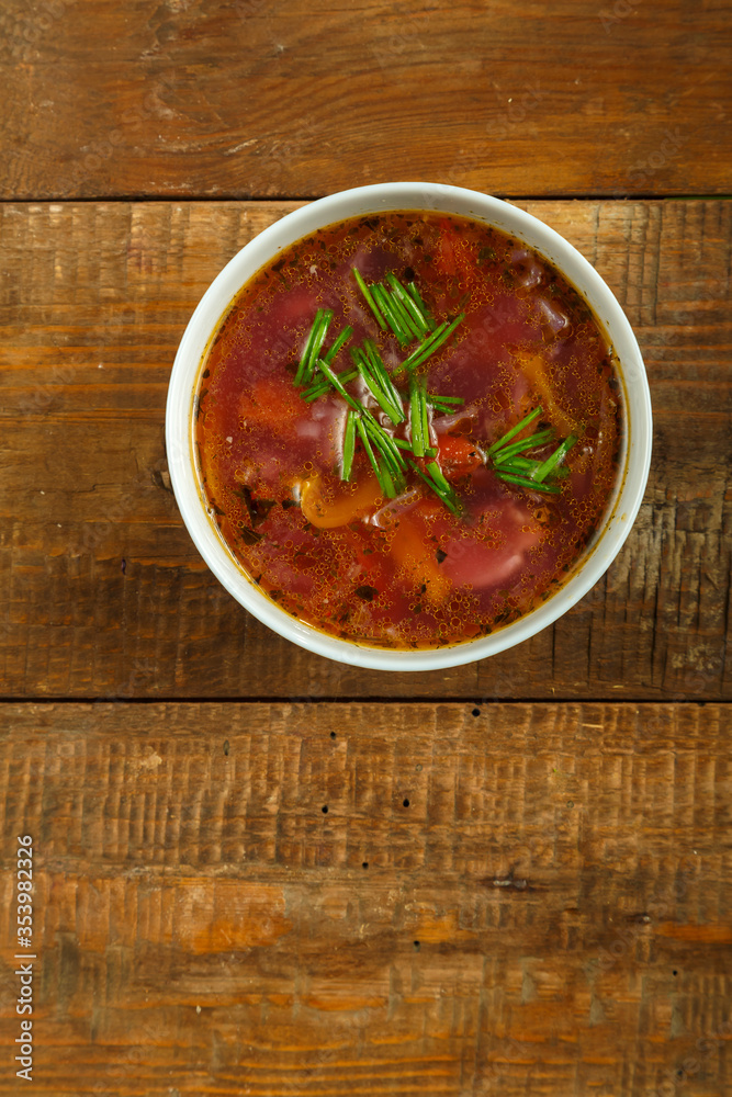 Gray dish of vegetable soup on a wooden table. Gray dish of vegetable soup on a wooden table.