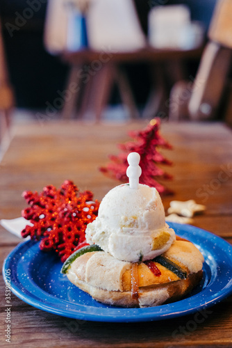 Rosca de reyes on the blue plate with ice cream, christmas decoration and baby Jesus photo