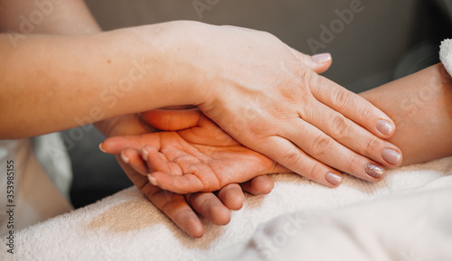 Close up photo of a hand massage procedure done by a professional masseur at the spa salon