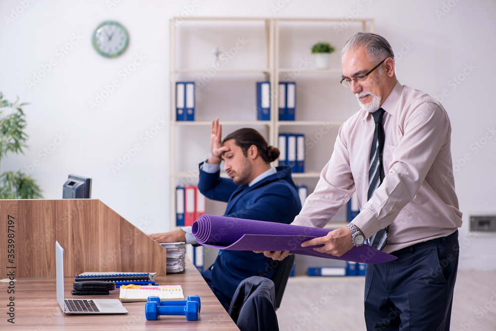 Two employees doing physical exercises at workplace