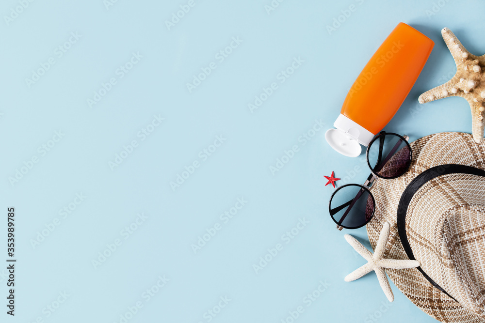 Beach accessories on pastel blue background top view. Summer background.