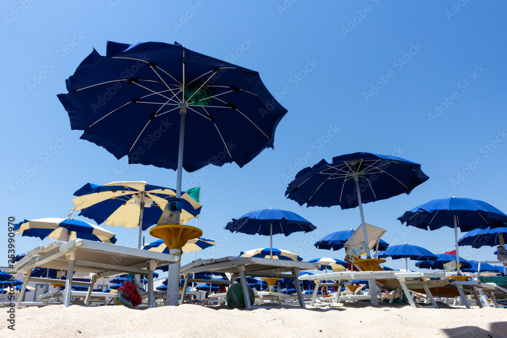 umbrellas open on the beach against the blue summer sky
