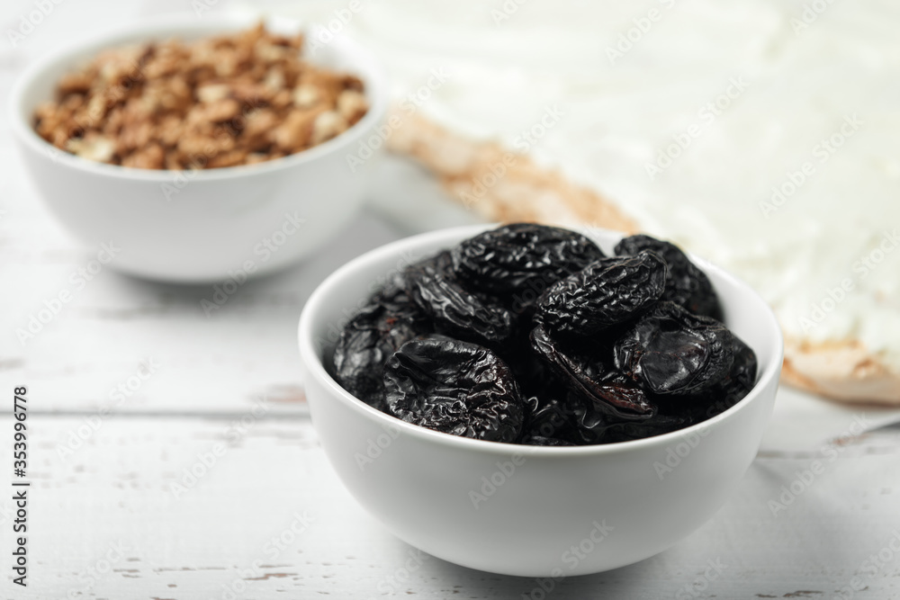 Prunes, walnuts and meringue cake on white colored old vintage wooden backdrop. Prunes, walnuts and meringue cake on white colored old vintage wooden backdrop.