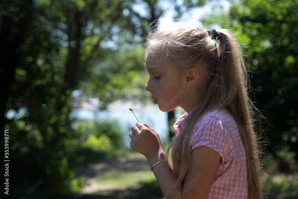 Cute blond little girl blowing a dandelion. Cute blond little girl blowing a dandelion.
