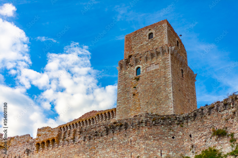 La rocca Maggiore dell'Albornoz ad Assisi, Umbria, Italia, con cielo blu e nuvole bianche