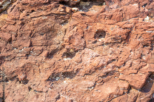 uneven surface of porous brown stone, rough weathered texture, background image, pattern for printing