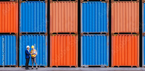 Panoramic of smart creative foreman and engineer woman control loading containers box from cargo freight ship for import export. Logistic, transportation, import and export concept. With copy space.