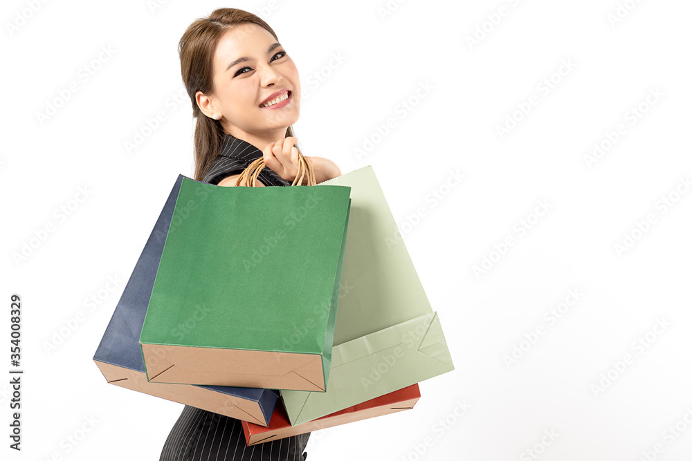 Portrait of young beautiful asian girl wearing black dress holding shopping bags and smile isolated over white background. Online shopping and black friday concept. Portrait of young beautiful asian girl wearing black dress holding shopping bags and smile isolated over white background. Online shopping and black friday concept.