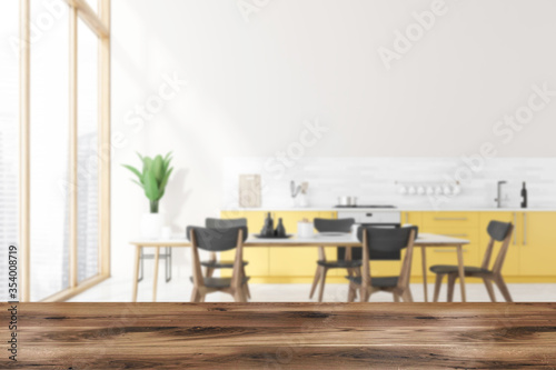Table in blurry kitchen with yellow countertops