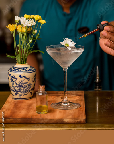 Martini alcohol cocktail garnished with flower. Art delicious cocktail in bar