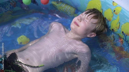 boy enjoying sun inside inflatable swimming pool