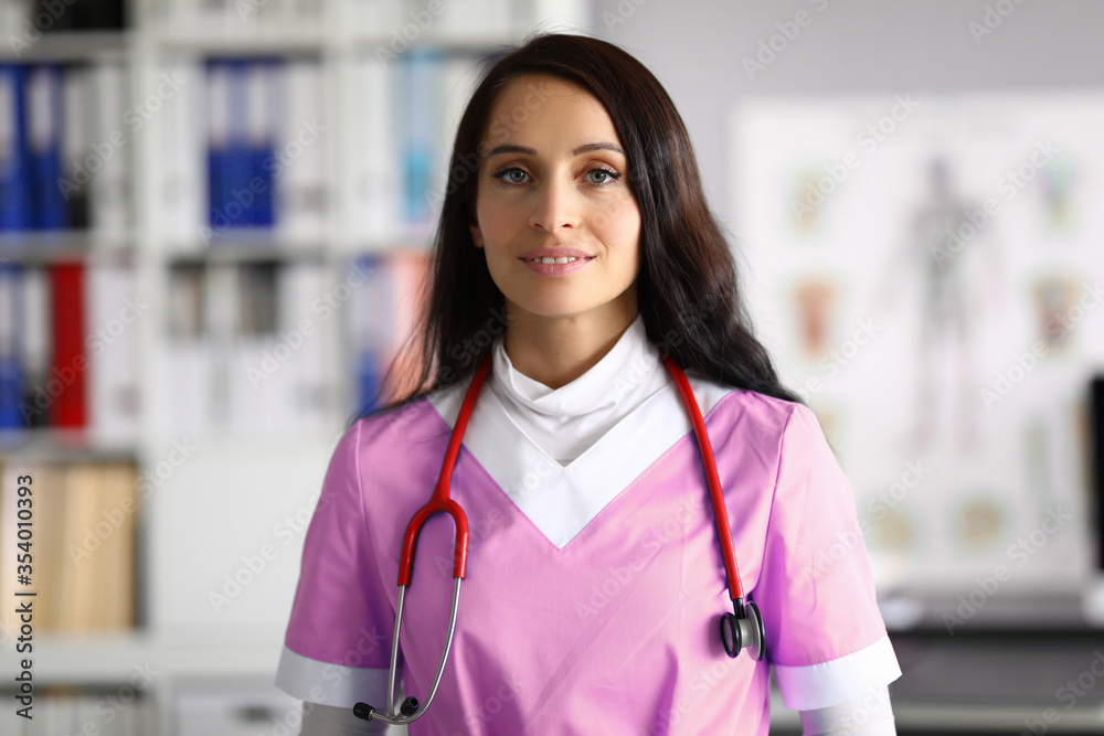 Beautiful woman doctor in uniform stands in office Beautiful woman doctor in uniform stands in office