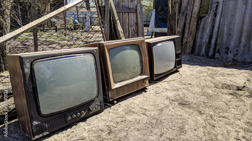 Three old TVs in the courtyard of a small Ukrainian village on a spring afternoon
