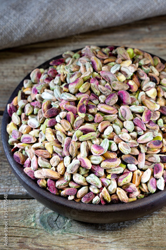 Pistachios in wooden bowl on rustic background 