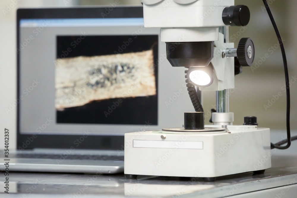 microscope and laptop on metal table. microscope and laptop on metal table.