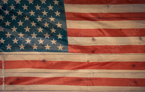 Vintage flag of the United States on a plank wooden surface.