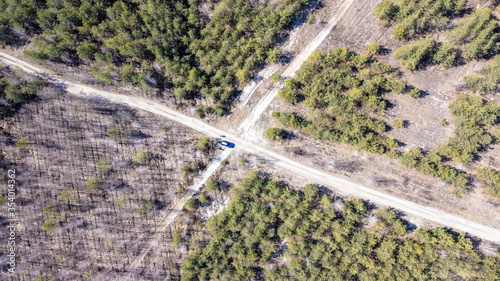 Aerial photography from a quadcopter, a car at the intersection of forest roads. Sunny day. spring