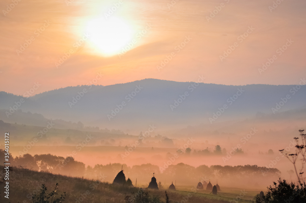 Obraz premium Morning fog over the field, beautiful mountains landscape.