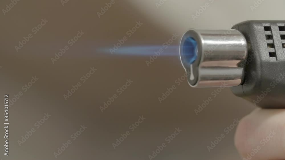 Slow motion lockdown shot of woman holding blowtorch in kitchen - Paris, France Slow motion lockdown shot of woman holding blowtorch in kitchen - Paris, France
