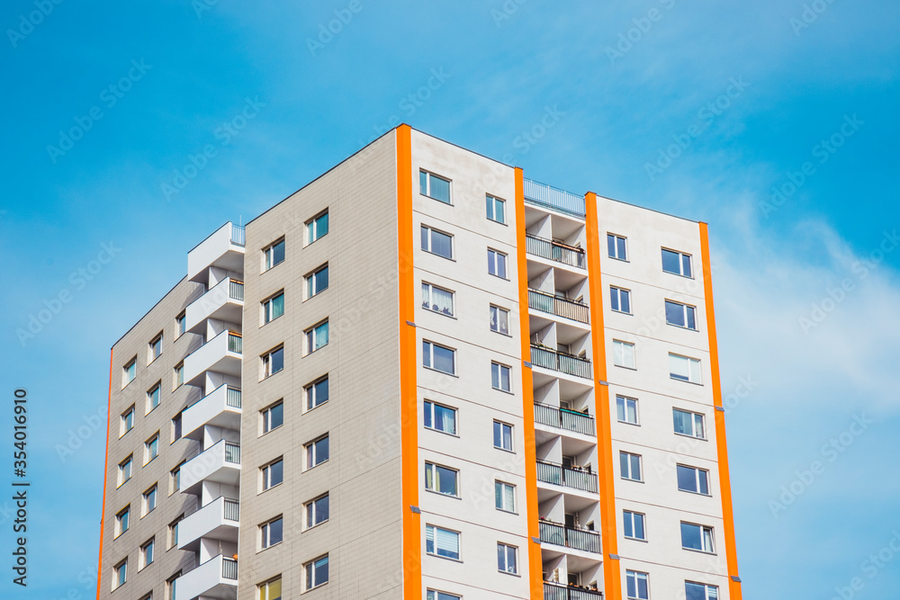 Building facade with orange stripes in contrast to the blue sky in the background, perfect vacations in a sunny day