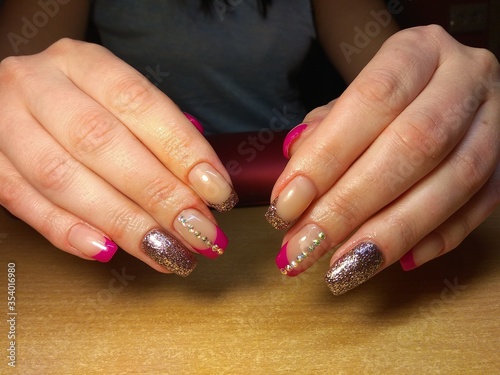 The manicurist excellently made her work a beautiful manicure with a polish gel on her hands and the client is happy 